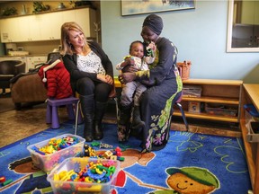 Minus Rafie, west central community resource centre coordinator, left, meets with Akuer and her daughter Amou, 2,  at Closer to Home in Calgary. Leah Hennel/Postmedia