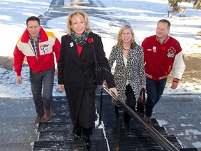 Frank King's children from left; Steve, Linda and Dave walk into vote with Calgary 2026 BidCo CEO Mary Moran, second from right, at a Olympic plebiscite advance polling station in the Memorial Park Library on Wednesday November 7, 2018. Frank King was the chairman and CEO of the 1988 Winter Olympics. Gavin Young/Postmedia