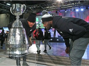 Calgary Stampeders James Vaughters, left, and DaVaris Daniels take a close look at the Grey Cup during media day at Grey Cup week in Edmonton on Thursday November 22, 2018. Gavin Young/Postmedia