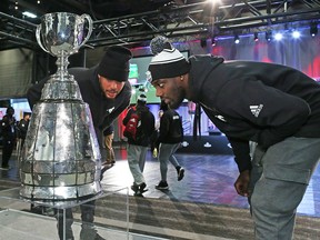 Calgary Stampeders James Vaughters, left, and DaVaris Daniels take a close look at the Grey Cup during media day at Grey Cup week in Edmonton on Thursday November 22, 2018.