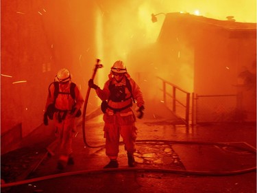 Firefighters battle the Camp Fire as it tears through Paradise, Calif., on Thursday, Nov. 8, 2018. Tens of thousands of people fled a fast-moving wildfire Thursday in Northern California, some clutching babies and pets as they abandoned vehicles and struck out on foot ahead of the flames that forced the evacuation of an entire town and destroyed hundreds of structures.