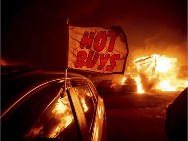 Flames consume a car dealership as the Camp Fire tears through Paradise, Calif., on Thursday, Nov. 8, 2018. Tens of thousands of people fled a fast-moving wildfire Thursday in Northern California, some clutching babies and pets as they abandoned vehicles and struck out on foot ahead of the flames that forced the evacuation of an entire town and destroyed hundreds of structures.