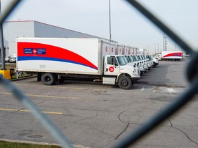 Idle Canada Post trucks sit in the parking lot of the Saint-Laurent sorting facility in Montreal during rotating strikes.