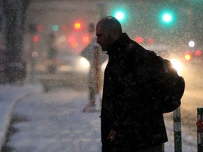 A pedestrian crosses 8 Ave at 8 St SW during the early snowy rush hour in downtown Calgary Friday, November 23, 2018. Jim Wells/Postmedia