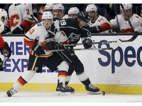 Calgary Flames left wing Johnny Gaudreau, left, battles Los Angeles Kings left wing Alex Iafallo for the puck during the second period of an NHL hockey game in Los Angeles, Saturday, Nov. 10, 2018.