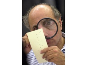 FILE - In this Nov. 24, 2000, file photo, Broward County, Fla., canvassing board member Judge Robert Rosenberg uses a magnifying glass to examine a disputed ballot at the Broward County Courthouse in Fort Lauderdale, Fla. Rosenberg was front and center 18 years ago in Florida's infamous recount in the presidential contest between Republican George W. Bush and Democrat Al Gore. Rosenberg, perhaps best remembered for eyeing ballots through a large looking glass, said in an Associated Press interview that he was brought in to lead the 2000 recount in Broward County and was determined to get it right.