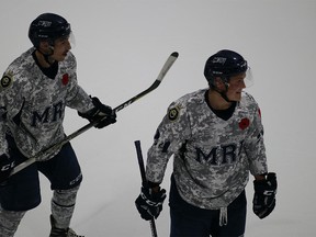 The Mount Royal Cougars salute the Canadian military Friday night at Flames Community Arenas.