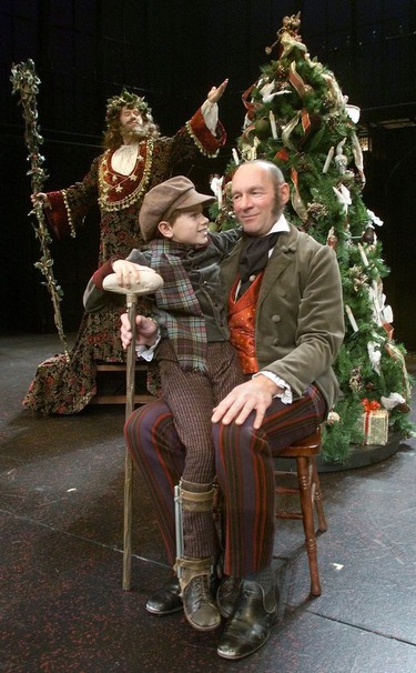 2001: As the Ghost of Christmas Present, played by Tony Eyamie hovers in the background, Tiny Tim played by Brendan Prost and Scrooge played by Stephen Hair connect. The players are preforming in the Theatre Calgary presentation of Charles Dicken's A Christmas Carol.  Photo by Grant Black/Calgary Herald
DATE PUBLISHED: THURSDAY, NOVEMBER 29, 2001 PAGE A1 * Calgary Herald Merlin Archive *