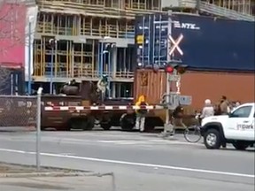Image captured from a video in which Calgarians are seen crossing between cars of a train blocking a downtown Calgary intersection on Nov. 2, 2018. A CP Rail line crosses 11 St. S.W., just south of 9th Ave S.W. Submitted