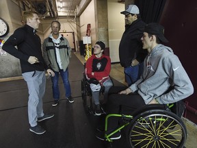 Jacob Wassermann, right, and Ryan Straschnitzki, centre, speak with University of Denver head coach David Carle at the University of Denver on Monday, Nov. 26, 2018.