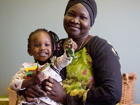 Akuer and her daughter Amou, 2, pose for a photo at Closer to Home in Calgary. Leah Hennel/Postmedia