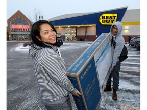 Noime and Lucky Ann Mendigoran carry their new purchase during Boxing Day sales from Best Buy at Northland mall in Calgary on Wednesday December 26, 2018. Darren Makowichuk/Postmedia