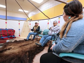 Elders Peter Weasel Moccasin, left, and Leroy Heavy Runner sit with school counsellor Cara Black Water, right, in a 2017 file photo taken in Kainai High School's teepee room.