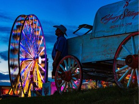 North American Midway worker Lee Kenyon found a quiet place to take a break from his midway game booth as the sun set at the Calgary Stampede on Monday July 9, 2018.  Gavin Young/Postmedia