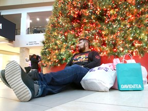 Eric Rangel takes a break from Christmas shopping  at centre court at Chinook Centre in southwest Calgary on Friday, December 21, 2018. Jim Wells/Postmedia