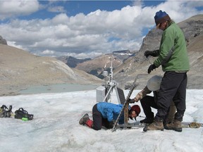 File photo: Research technician May Guan (left), glaciologist Scott Munro, (centre) and glaciology technician Steve Bertollo take careful measurements as they install an automatic weather station on the Rockiesí Peyto Glacier. The Peyto Glacier and part of Banff National Park has lost about 70 per cent of its mass in the last 50 years.