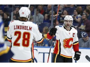 The Calgary Flames' Mark Giordano, right, is congratulated by Elias Lindholm after scoring during the first period of an NHL hockey game against the St. Louis Blues Sunday, Dec. 16, 2018, in St. Louis.