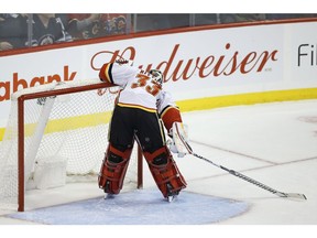 Calgary Flames goaltender David Rittich (33) kisses the post after a Winnipeg Jets' shot rang off the post during third period NHL action in Winnipeg on Thursday.