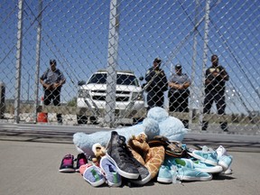 In this June 21, 2018, photo shoes and a teddy bear, brought by a group of U.S. mayors, are piled up outside a holding facility for immigrant children in Tornillo, Texas, near the Mexican border.
