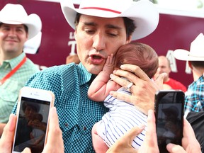 Prime Minister Justin Trudeau cradles a baby during a stop at a pancake breakfast in Marda Loop on July 15, 2017.