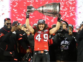 Stampeders linebacker Alex Singleton hoists the  Grey Cup at Commonwealth Stadium in Edmonton on Nov. 25, 2018.