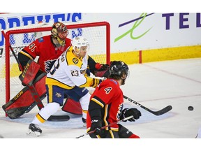 The Nashville Predators' Rocco Grimaldi tracks the puck in front of Calgary Flames goaltender Mike Smith in NHL action at the Scotiabank Saddledome in Calgary on Saturday. Photo by Gavin Young/Postmedia