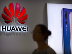 A shopper walks past a Huawei store at a shopping mall in Beijing Wednesday, July 4, 2018.