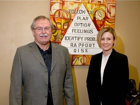 Volunteer Ray Graham poses with Jerilyn Dressler, executive director, in front of the Roberts' Model of Crisis Intervention at the Calgary Distress Centre in Calgary. Jim Wells/Postmedia