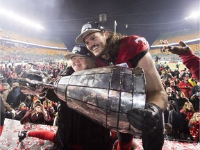 Calgary Stampeders linebacker Alex Singleton holds the Grey Cup with sister Ashley after defeating the Ottawa Redblacks in the Grey Cup in Edmonton on Nov. 25, 2018.