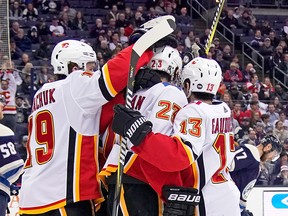 Sean Monahan of the Calgary Flames is congratulated by his teammates after scoring in the third period against the Columbus Blue Jackets on Dec. 4, 2018 at Nationwide Arena in Columbus, Ohio.