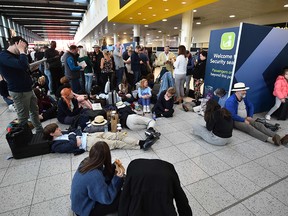 Passengers wait at the North Terminal at London Gatwick Airport, south of London, on Dec. 20, 2018 after all flights were grounded due to drones flying over the airfield.