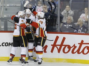 Flames celebrate a third period goal by forward Mark Jankowski (centre) against the Winnipeg Jets on Thursday, Dec. 27, 2018.