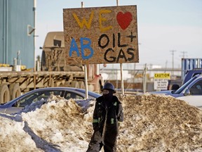 An oilfield worker watches hundreds of truckers who joined the Truck Convoy in Nisku on December 19, 2018 to support the oil and gas industry in Alberta.