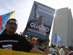 Anti-Maduro demonstrators gather as one holds a poster of Venezuelan opposition leader Juan Guaido, outside the Federal Building on January 26, 2019 in Los Angeles, California.