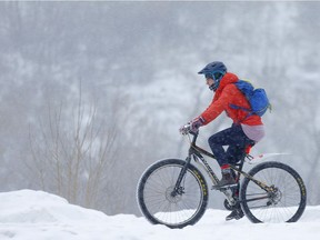 A cyclist heads west along the Bow River during a snowfall  in Calgary, on Wednesday January 23, 2019. Leah Hennel/Postmedia