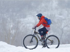 A cyclist heads west along the Bow River during a snowfall  in Calgary, on Wednesday January 23, 2019. Leah Hennel/Postmedia