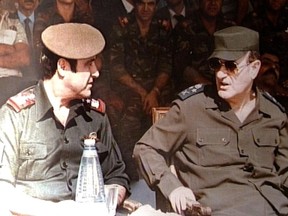 An image taken in 1984 shows the late Syrian president Hafez al-Assad (R) with his youngest brother Rifaat (L) at a military ceremony in Damascus.