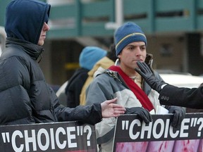 A passerby engages in debate with anti-abortion protesters in Calgary affiliated with the Canadian Center for Bioethical Reform.  herald files