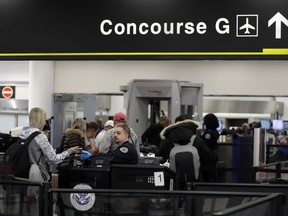 A Transportation Security Administration officer works at the entrance to Concourse G at Miami International Airport, Friday, Jan. 11, 2019, in Miami. The airport is closing Terminal G this weekend as the federal government shutdown stretches toward a fourth week because security screeners have been calling in sick at twice the airport's normal rate.