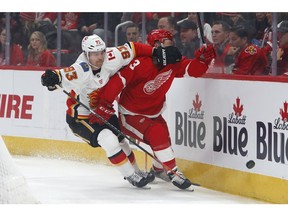 Calgary Flames center Sam Bennett (93) and Detroit Red Wings defenceman Nick Jensen (3) battle for the puck in the first period of an NHL hockey game Wednesday, Jan. 2, 2019, in Detroit.