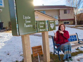 Margot Baker sits beside the little free pantry she has next to her free library at her home in Abbeydale on Wednesday January 2, 2019. Baker says she has a big spike in demand at the pantry this winter.  Gavin Young/Postmedia