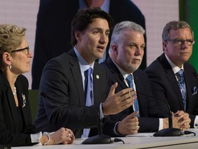At the Paris COP21 meeting, then-Ontario Premier Kathleen Wynne (left), then-Quebec Premier Philippe Couillard and then-Saskatchewan Premier Brad Wall listen as Prime Minister Justin Trudeau speaks.