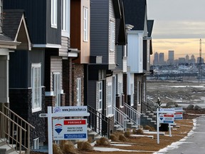 Attached homes for sale in the Livingstone community with the Calgary skyline in the distance on Wednesday, Jan. 30, 2019. CREB is forecasting another tough year for home sales.