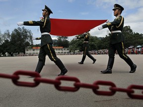 Soldiers carry a Chinese national flag at a military base during an open day event of the Chinese People's Liberation Army (PLA) in Hong Kong on June 29, 2014.