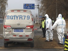 Workers disinfect passing vehicles on the outskirts of Beijing, China, on Nov. 23, 2018, after an outbreak of African swine fever in the area. Officials fear the disease could destroy Alberta's pork industry if it turns up in Canada.