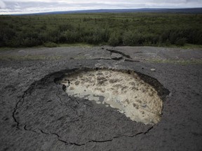 This Aug. 12, 2009, photo shows a section of the vital Dempster Highway linking southern Canada with the Northwest Territories after it collapsed because warming temperatures caused the permafrost below to thaw. A new highly detailed study of climate change and the North suggests impacts on roads and other infrastructure will be even more severe than anticipated.