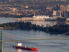 A oil tanker is guided by tug boats as it goes under the Lions Gate Bridge at the mouth of Vancouver Harbour.