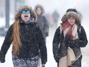 A woman sticks out her tongue as snow falls in Kingston, Ont., on Jan. 30, 2019. Frigid temperatures and weather warnings stretch from Manitoba to Newfoundland.