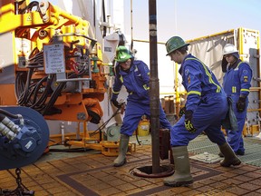 Apprentices Dan Brook and Bradley Williams are guided by instructor Clint Dyck as they are trained to lay down drill pipe on a rig floor on January 20, 2016 at Precision Drilling in Nisku, Alta.