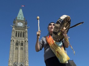 Chief Marcia Brown Martel sings outside parliament buildings following a government news conference announcing a compensation package for indigenous victims of the '60s Scoop, in Ottawa on Friday, October 6, 2017.